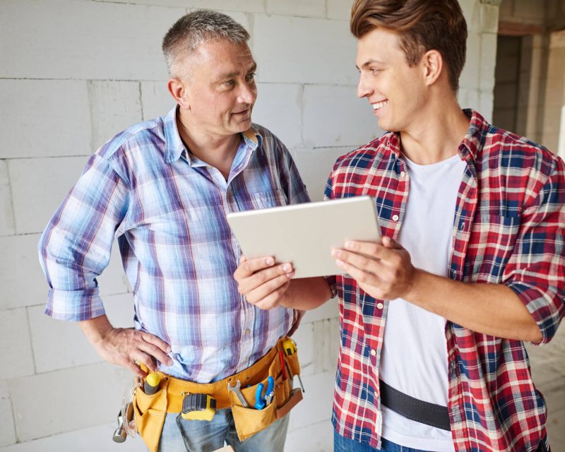 Blue Collar Worker Showing Tablet to Fellow Worker